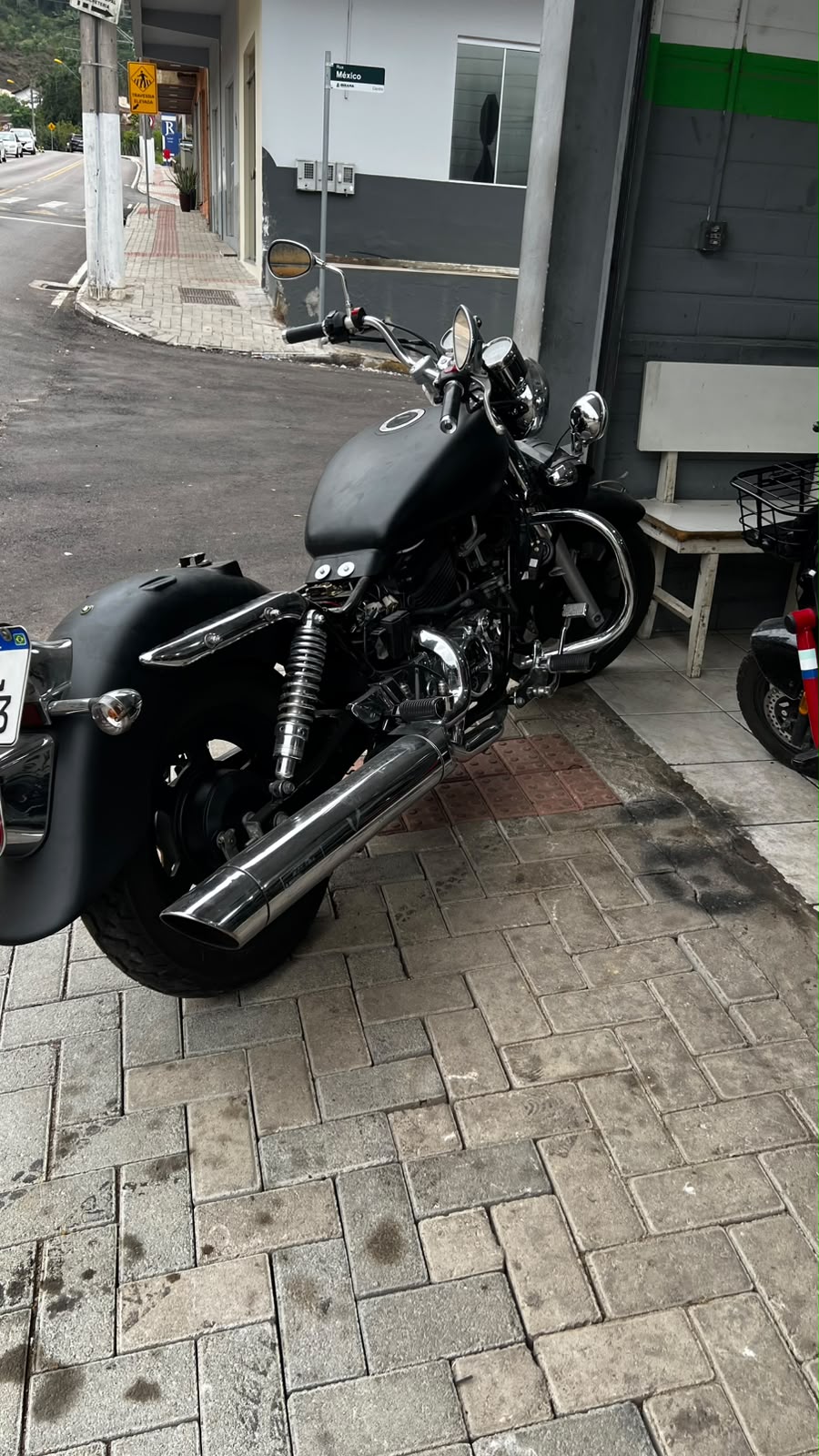 Moto custom estacionada em frente à Brayan Motos