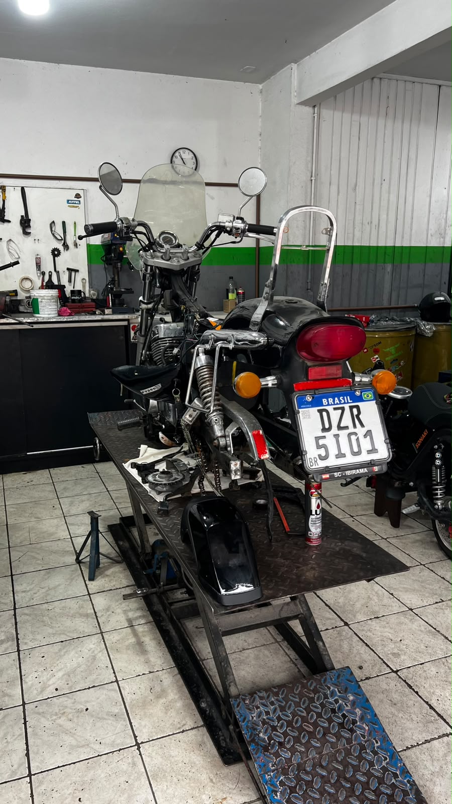 Moto custom desmontada no elevador da oficina